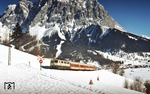 111 099 mit einem Nahverkehrszug von Innsbruck nach Reutte in Tirol ("Korridorzug") vor der Kulisse der Zugspitze bei Lermoos. (04.02.1982) <i>Foto: Peter Schiffer</i>