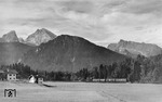 Vor der Kulisse des Watzmann (2713 m, links) und dem Hochkater (2607 m) ist P 124, bestehend aus der Doppeleinheit ET 90 03 und ET 90 01, auf der Königsseebahn nach Berchtesgaden nahe Schwobbrücke unterwegs. (1955) <i>Foto: Carl Bellingrodt</i>
