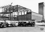 Das neue Empfangsgebäude wurde in mehreren Bauabschnitten hochgezogen. Als erster Abschnitt entstand der Südflügel mit Schalterhalle und Uhrenturm (rechts). Danach folgte die Errichtung der von einer Stahlskelettkonstruktion getragenen Empfangshalle. Den letzten Bauabschnitt bildete der Nordflügel. (17.04.1934) <i>Foto: RVM (Eckler)</i>