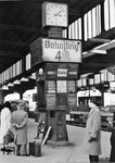Der Zugzielanzeiger auf dem Bahnsteig 4 im Düsseldorfer Hauptbahnhof hatte Mitte der fünfziger Jahre seine besten Zeiten schon hinter sich - heute aber ein einzigartiges Dokument, das zeigt, dass es lange dauerte, bis die Bahnanlagen in allen Bereichen von den Altlasten des Zweiten Weltkriegs befreit werden konnten. (1955) <i>Foto: Walter Eckler</i>