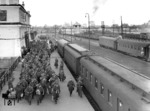 Soldaten eines Truppentransports bereiten sich auf die Weiterfahrt im Bahnhof Brest-Litowsk vor. Der Bahnhof war im Zweiten Weltkrieg Grenzbahnhof zwischen "Generalgouvernement" und "Ostland", heute zwischen Polen und Weißrußland. Rechts steht ein alter bayerischer D-Zug-Wagen. (1942) <i>Foto: Ittenbach (RVM)</i>