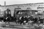 Vorbei an den Zugtrümmern huschen Reisende auf einem unbekannten Norddeutschen Bahnhof, die offenkundig gerade von einer Hamsterfahrt zurückkehren. (1945) <i>Foto: Walter Hollnagel</i>