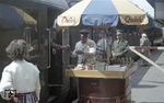 Wie sehr vermisst man auf heutigen Bahnhöfen diese früher selbstverständlichen Buffetwagen mit Angeboten von Schokolade über Zeitungen bis zur Bockwurst mit Brot mit Service, hier am D 148 im Bahnhof Flensburg. (02.08.1957) <i>Foto: Walter Hollnagel</i>