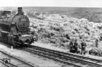 An eine unbekannte Bahnstation werden Heuballen zur Verladung herangefahren. Drei Soldaten haben ein wachsames Auge auf das Geschehen. 57 3279 vom Bw Baranowitsche "Bara" (zwischen Brest und Minsk) wurde kurzfristig an das Bw Borisow verliehen (etwa 80 km nordöstlich von Minsk), wie die weiße Tafel an der Rauchkammer verrät. (1942) <i>Foto: RVM (Ittenbach)</i>