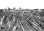 Blick vom Dach des Münchener Zentralstellwerks auf den Hauptbahnhof. Neben zwei parallel ausfahrenden E 44 (Mitte und links) warten eine V 60 und E 60 (rechts) auf neue Rangieraufgaben. (01.06.1962) <i>Foto: Walter Hollnagel</i>