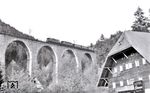 Wegen gestiegener Anforderungen auf der Höllentalbahn – schwerere Lokomotiven und höhere Geschwindigkeiten – wurde ab 26. August 1926 die heutige Ravennabrücke, ein gemauertes Steinviadukt mit neun Bögen und einer Bogenweite von 20 m, realisiert und damit auch die Strecke begradigt und um 38 Meter verkürzt. Die neue Brücke wurde 36 Meter hoch, 224 Meter lang und überwindet eine Steigung von 12 Metern. Die Pfeiler mussten teilweise bis zu 30 Meter tief im Boden verankert werden. Hier überqueren zwei E 44.11 das Viadukt bei Hinterzarten. Nebenbei ist sie die einzige beheizbare Brücke der Deutschen Bahn. (20.05.1967) <i>Foto: Kurt Eckert</i>