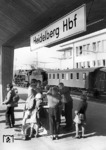 Kostenlose Erfrischungen für Reisende auf dem Bahnsteig gab es früher auf fast jedem Bahnhof, hier zum Vergnügen einiger Schulkinder auf dem (neuen) Heidelberger Hauptbahnhof. Eine 39er mit badischen Personenwagen der 3. Klasse rundet die Szene ab. (30.09.1955) <i>Foto: Walter Hollnagel</i>