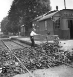 Nicht etwa die verlorene Kohlenladung eines Güterwagens, sondern die angelieferte Hausbrandversorgung mit Braunkohlenbriketts wird durch den Angestellten des Bahnhofs Watzerath an der Bahnstrecke Prüm—Pronsfeld aus den Gleisen beseitigt. (1931) <i>Foto: RBD Köln (Felten)</i>