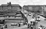Blick auf die Bahnanlagen des Ludwigshafener Hauptbahnhofs mit der 1889/90 erbauten 114 m langen Straßenbrücke, die 23 Gleise überspannte. Unter der Brücke steht eine P 8. Ansonsten herrscht auf der Straße wie auch im Bahnhof reger Verkehr. Im Hintergrund sieht man links das Stadthaus Nord, einen neuklassizistischen Dreiflügelbau aus dem Jahr 1913. (1930) <i>Foto: RVM</i>
