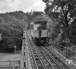 Ein Wagen der Nerobergbahn auf dem Viadukt nahe der Talstation. Die Nerobergbahn ist eine im Jahre 1888 errichtete Wasserlast- und Zahnstangen-Standseilbahn im Norden Wiesbadens. Sie führt vom Nerotal auf den Neroberg, wobei sie auf einer Länge von 438 m und bei einer durchschnittlichen Steigung von 19 % einen Höhenunterschied von 83 m überwindet. (06.1968) <i>Foto: Reinhard Todt</i>