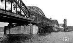 Die Hohenzollernbrücke ging unter der Leitung des Oberingenieurs Alfred Schön von der Firma Krupp Stahlbau Rheinhausen am 8. Mai 1948 wieder zweigleisig in Betrieb. Beim Wiederaufbau ließ man den (südlichen) Straßenbrückenteil weg, so dass die Brücke anfangs nur aus drei einzelnen Brückenüberbauten bestand. In den 1950er Jahren erfolgte der viergleisige Ausbau (Foto), der z.T. noch mit einer Schaper-Krupp-Reichsbahn-Brücke (SKR) vollzogen wurde, da keine Alternativen vorhanden waren. Die SKR-Brücke war ein schnell aufstellbares Behelfs- oder Notbrücken-System aus dem Zweiten Weltkrieg, um zerstörte Eisenbahnbrücken zu ersetzen. (11.1952) <i>Foto: Karl Wyrsch, Slg. D. Ammann</i>